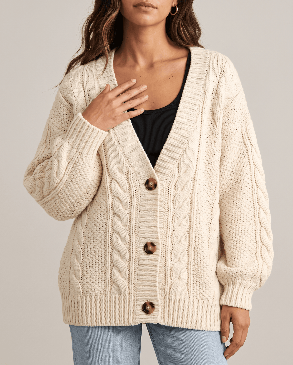 Close-up of cream rope cable and moss stitch knit with button placket