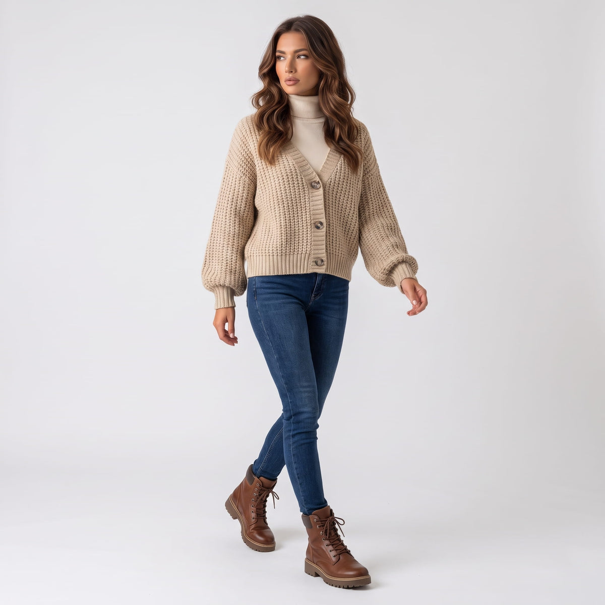 Full-length look with beige chunky knit cardigan, blue jeans and brown boots