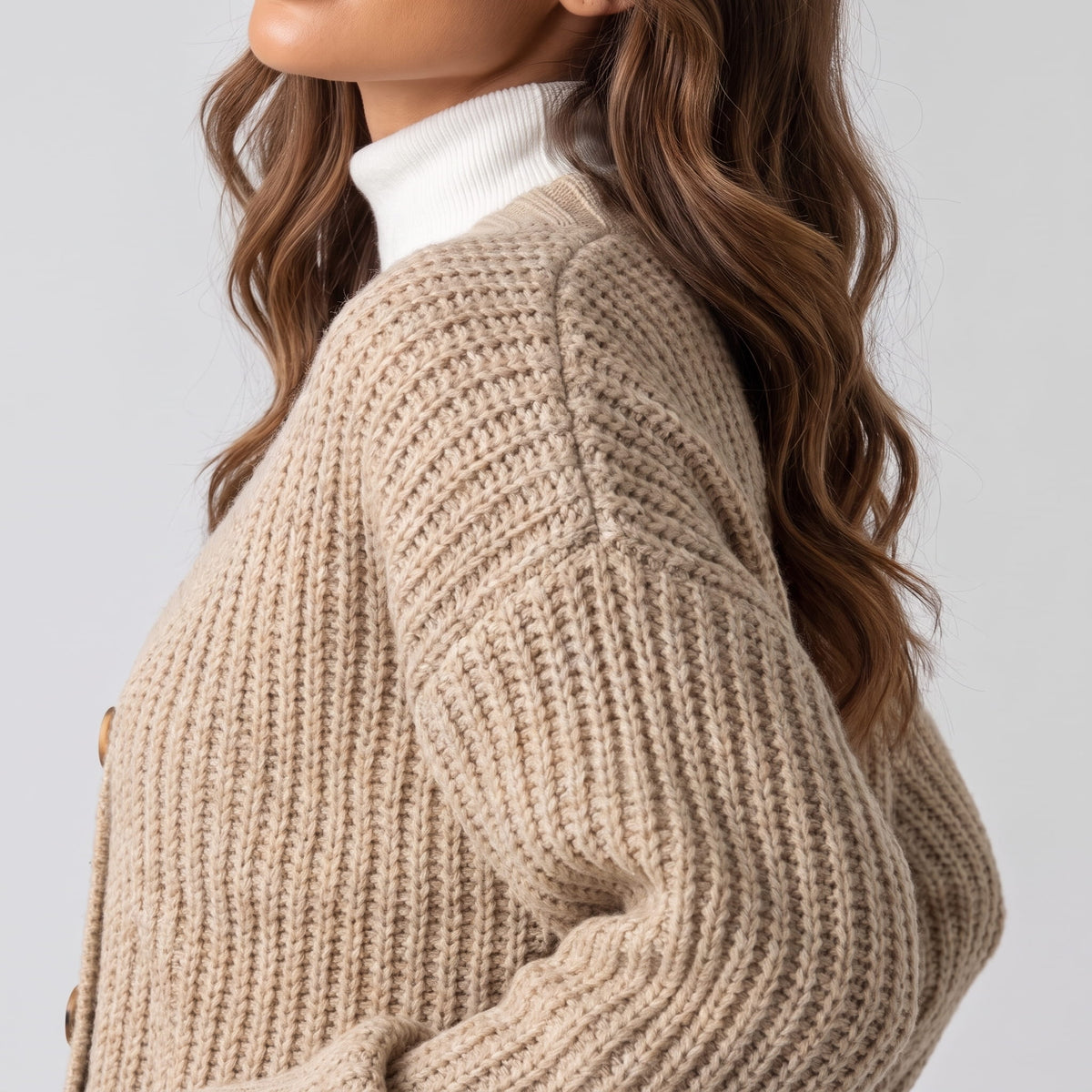 Close side view of beige chunky ribbed knit cardigan and sleeve