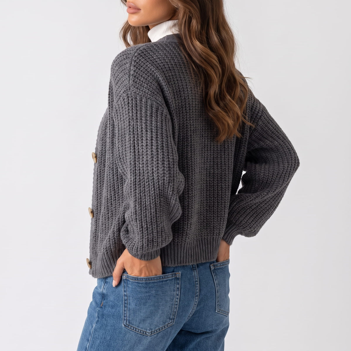 Back view of gray chunky ribbed knit cardigan worn with blue jeans