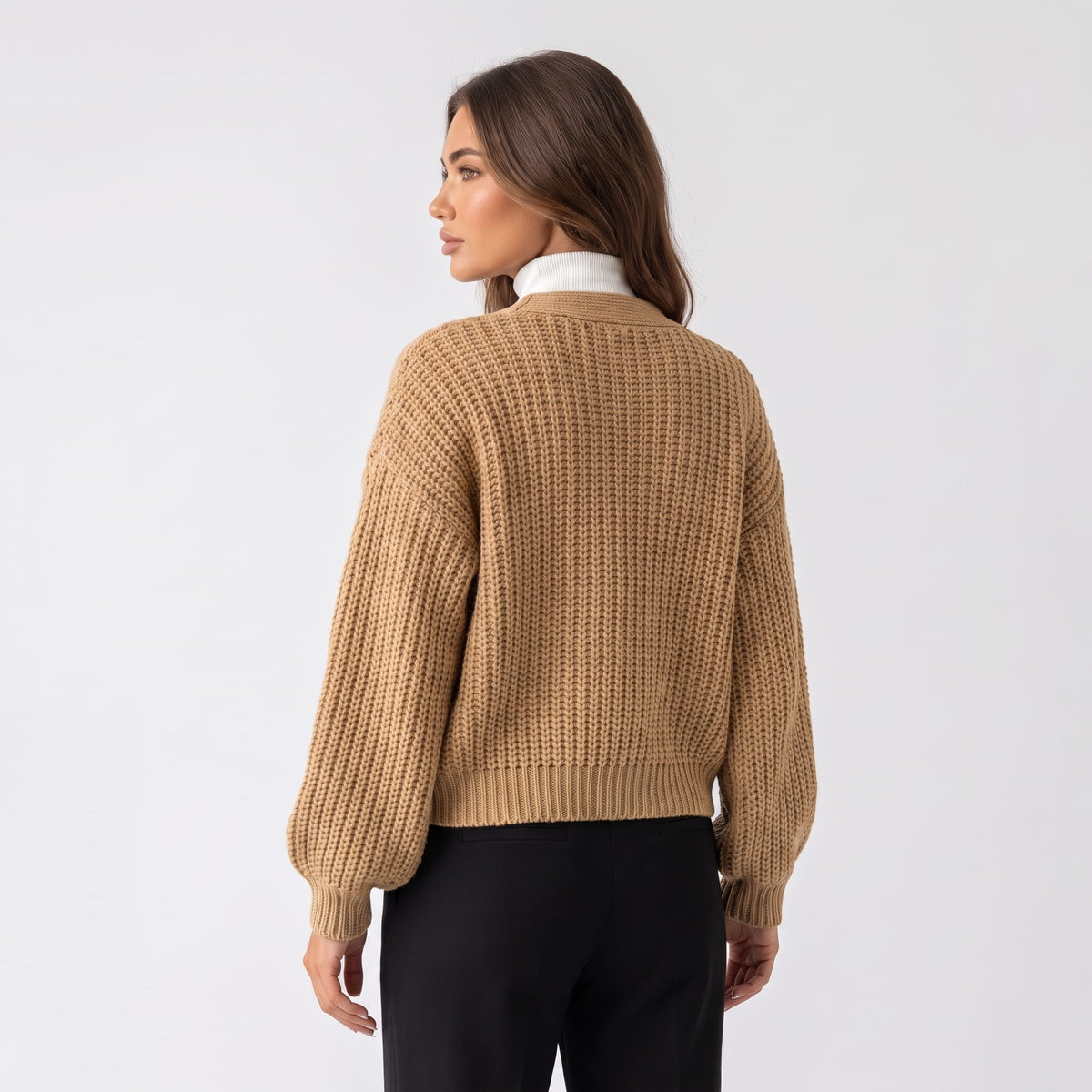Back view of khaki chunky knit cardigan with balloon sleeves and black trousers
