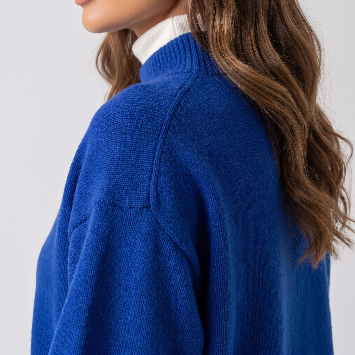 Side view of blue sweater showing the raglan seam and sleeve