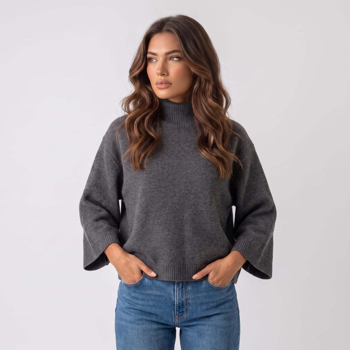 Dark gray boxy sweater with funnel collar worn with jeans, shown from the front