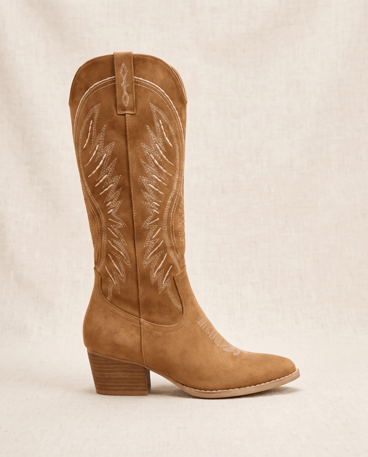 Single brown cowboy boot in side profile showing pointed toe and stacked heel
