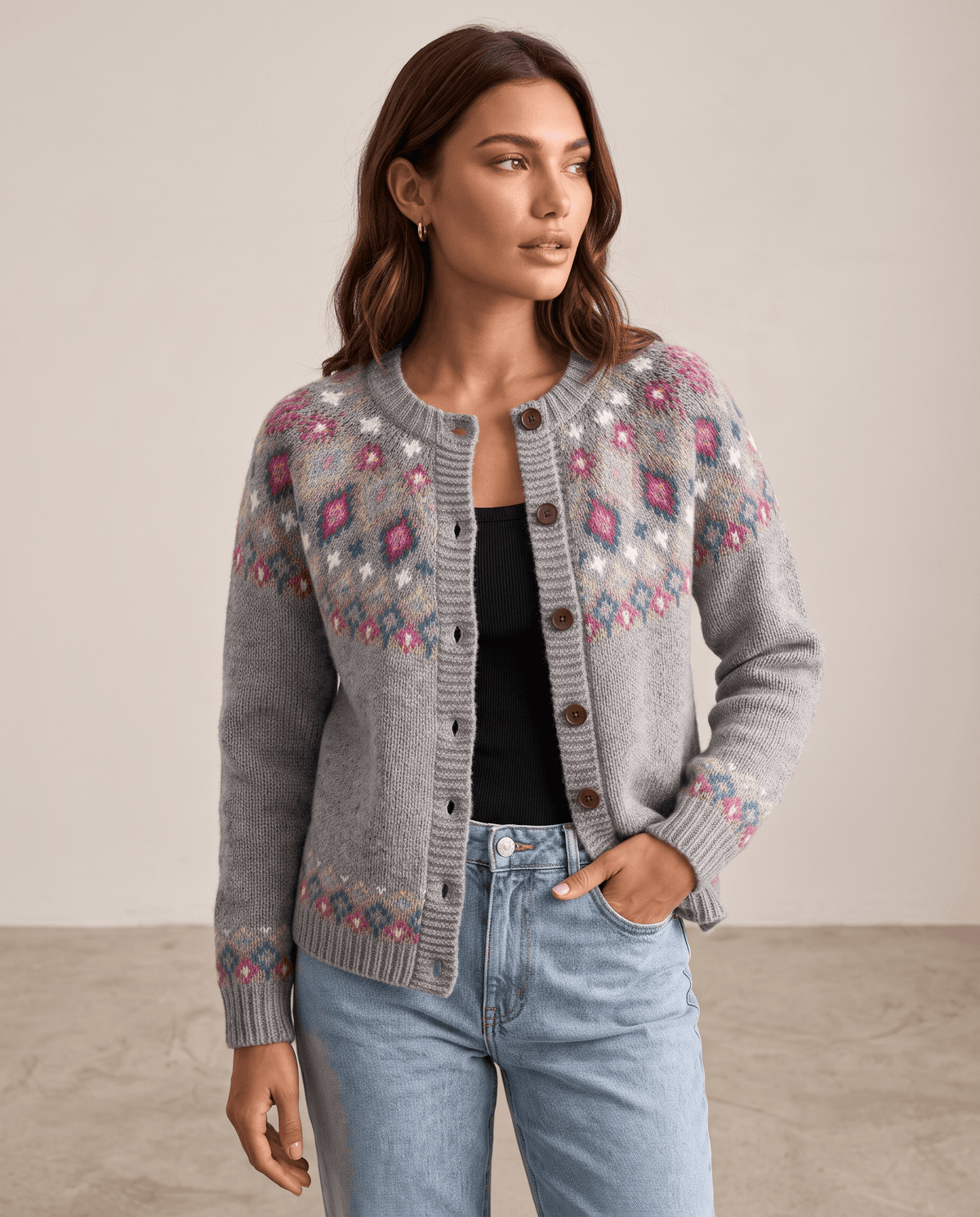Three-quarter view of a gray Fair Isle cardigan worn with a black top and jeans