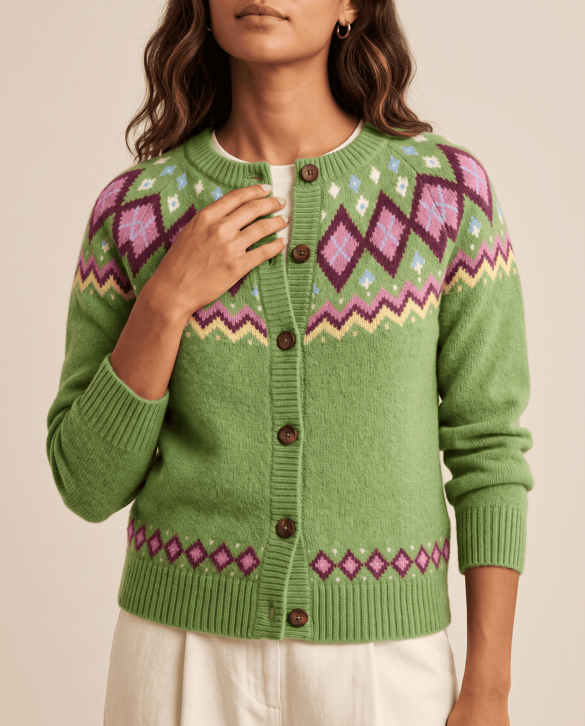 Close-up of green Fair Isle diamond pattern with brown buttons and ribbed trim