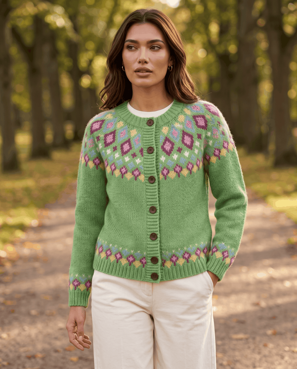 Green Fair Isle cardigan styled with cream trousers on an outdoor path