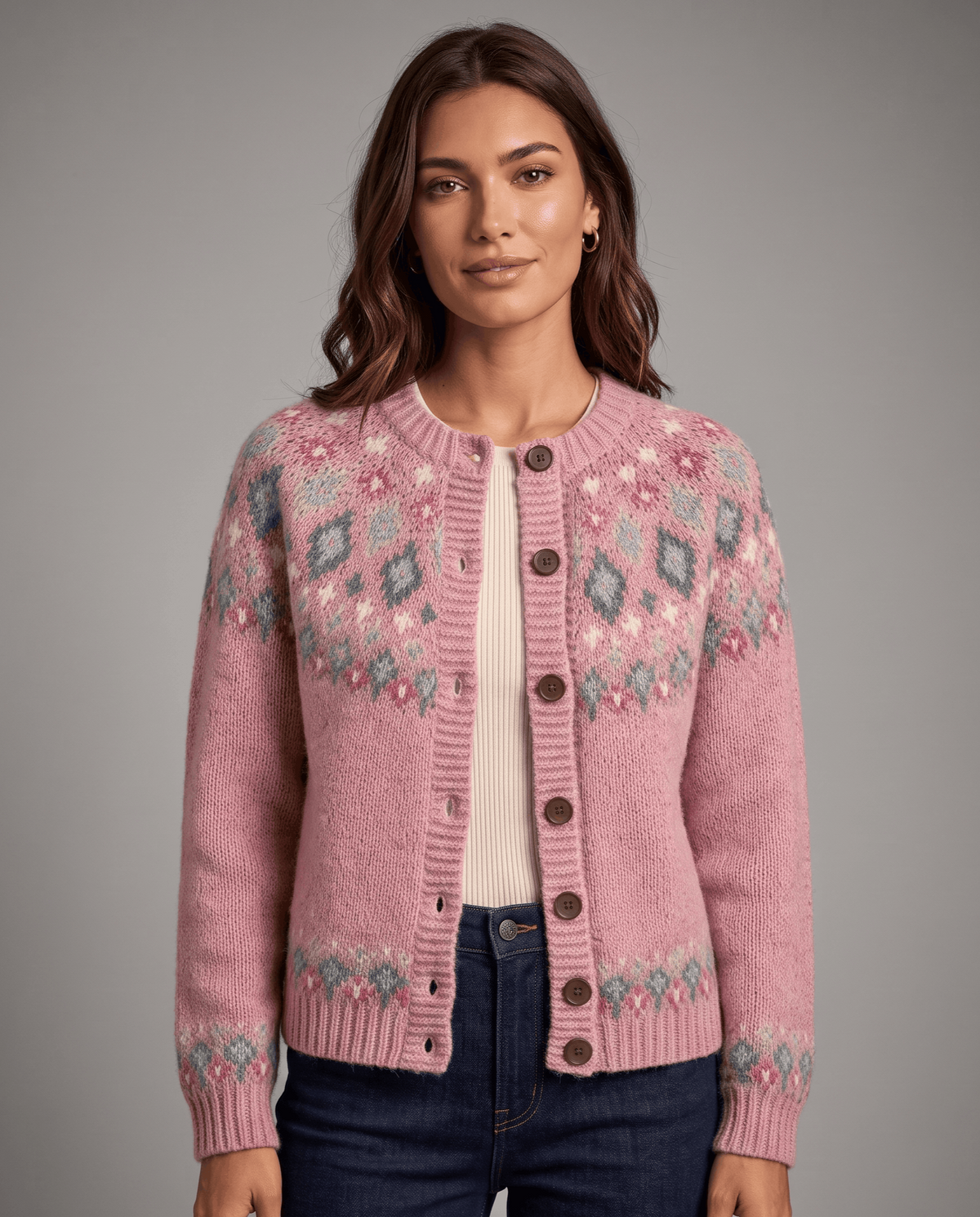 Woman wearing a pink women's Fair Isle cardigan with brown buttons and jeans, front view