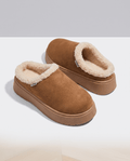 Pair of brown slippers with a soft cream shearling-look lining and cushioned platform soles.