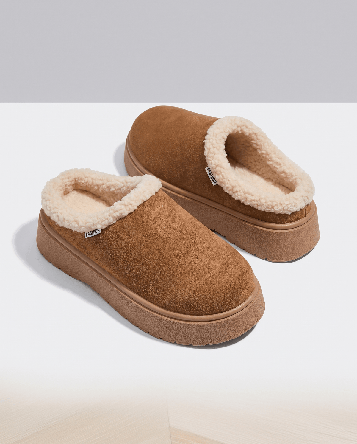 Pair of brown slippers with a soft cream shearling-look lining and cushioned platform soles.