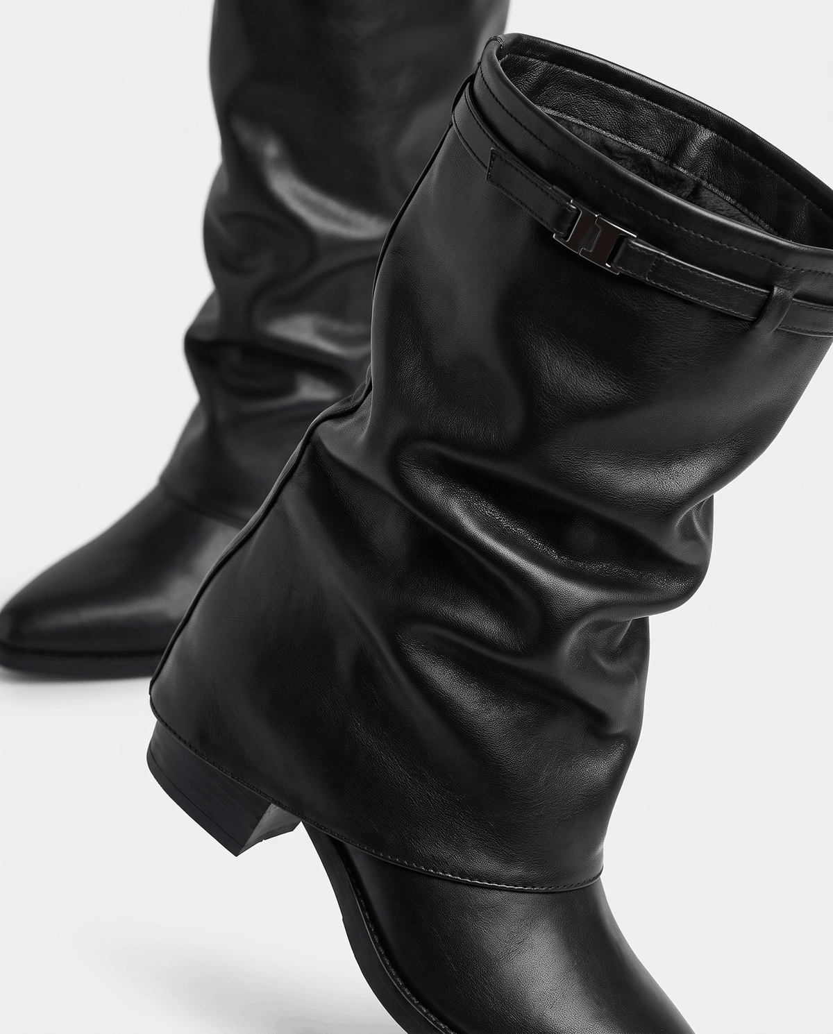 Close-up of the black cuff strap, buckle and slouched shaft