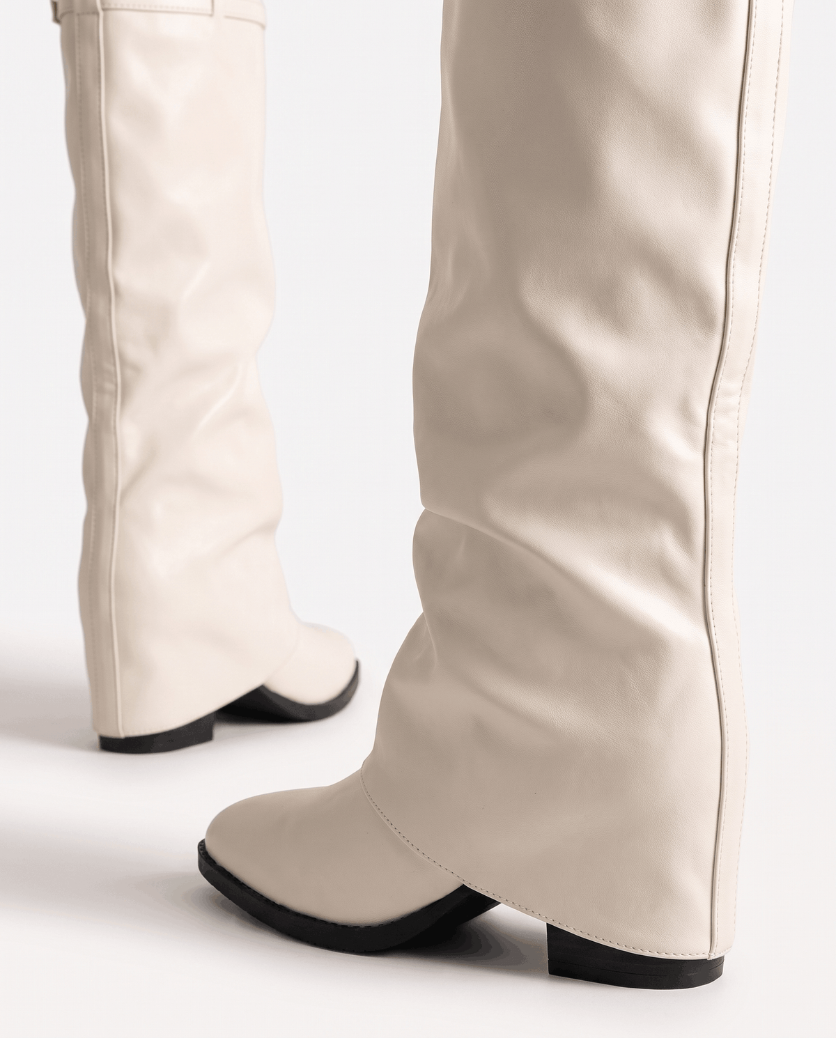 Back view of cream boots with the folded shaft covering the heel