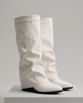 Knee-high fold-over slouch boots in cream leather-look finish on a white display block