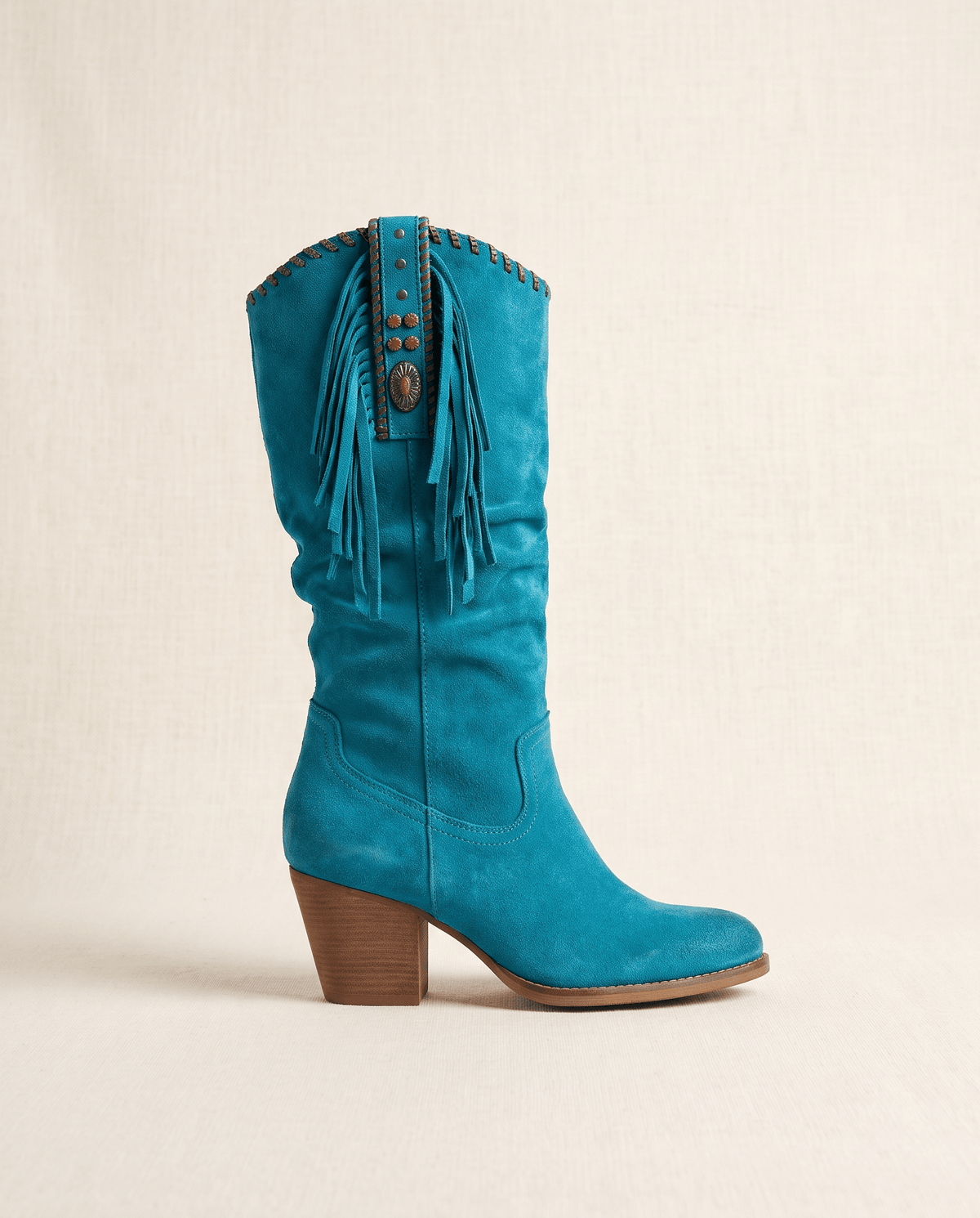 Single blue western boot in side profile against a warm cream backdrop