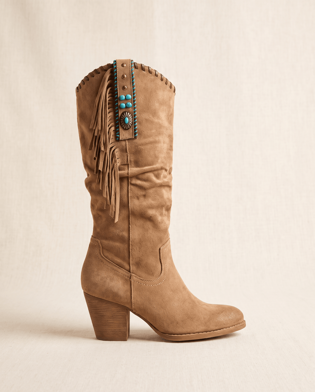 Single brown fringe boot in side profile against a soft cream backdrop
