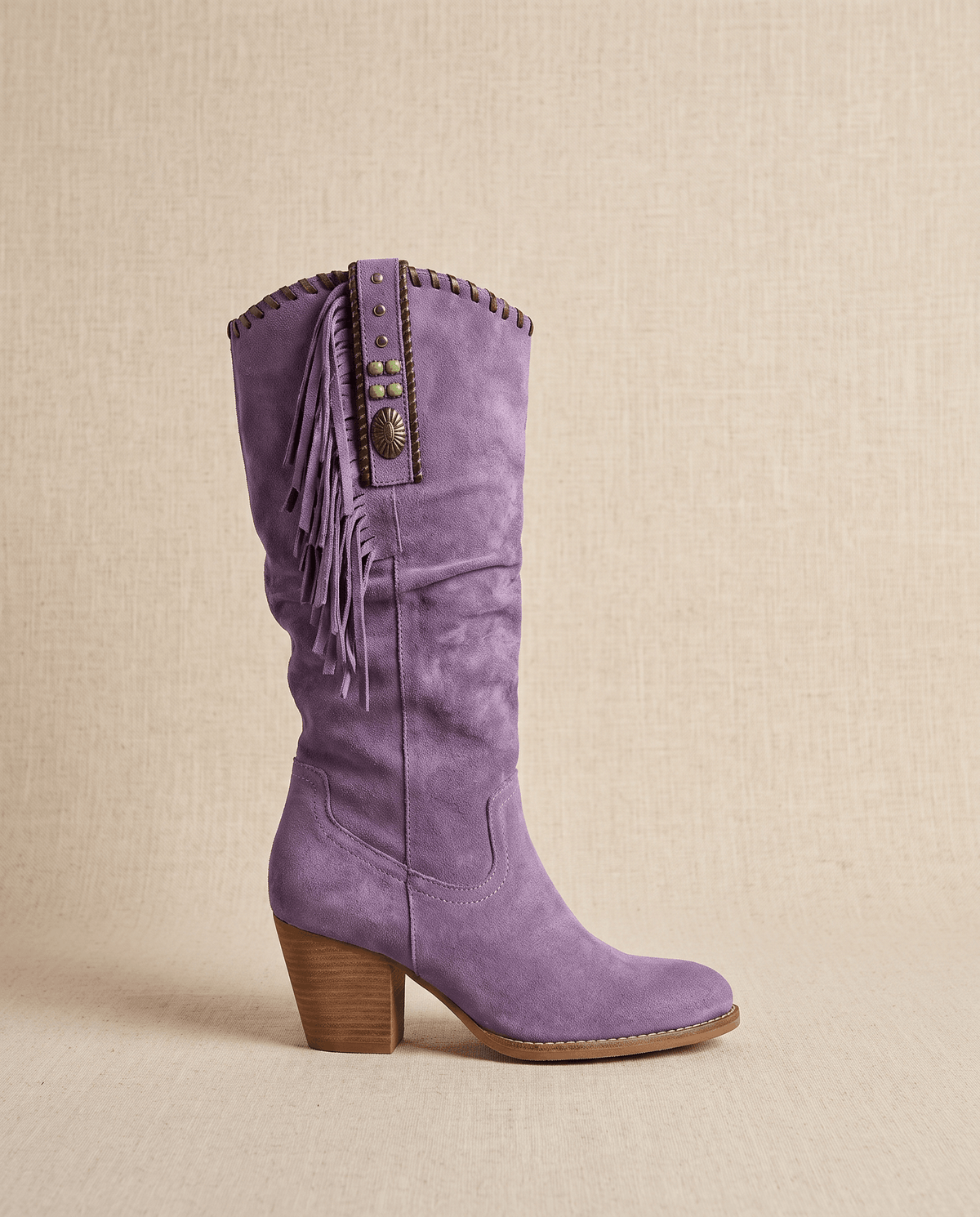 Single purple western boot in side profile showing fringe and stacked heel