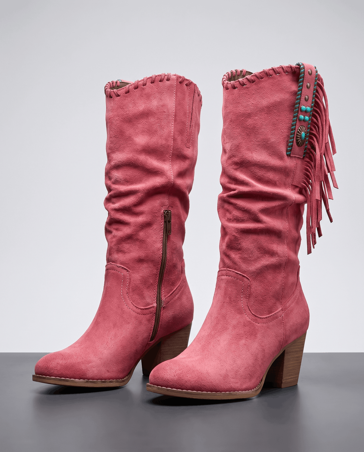 Pair of red fringe cowboy boots with slouchy shafts, concho straps and stacked heels