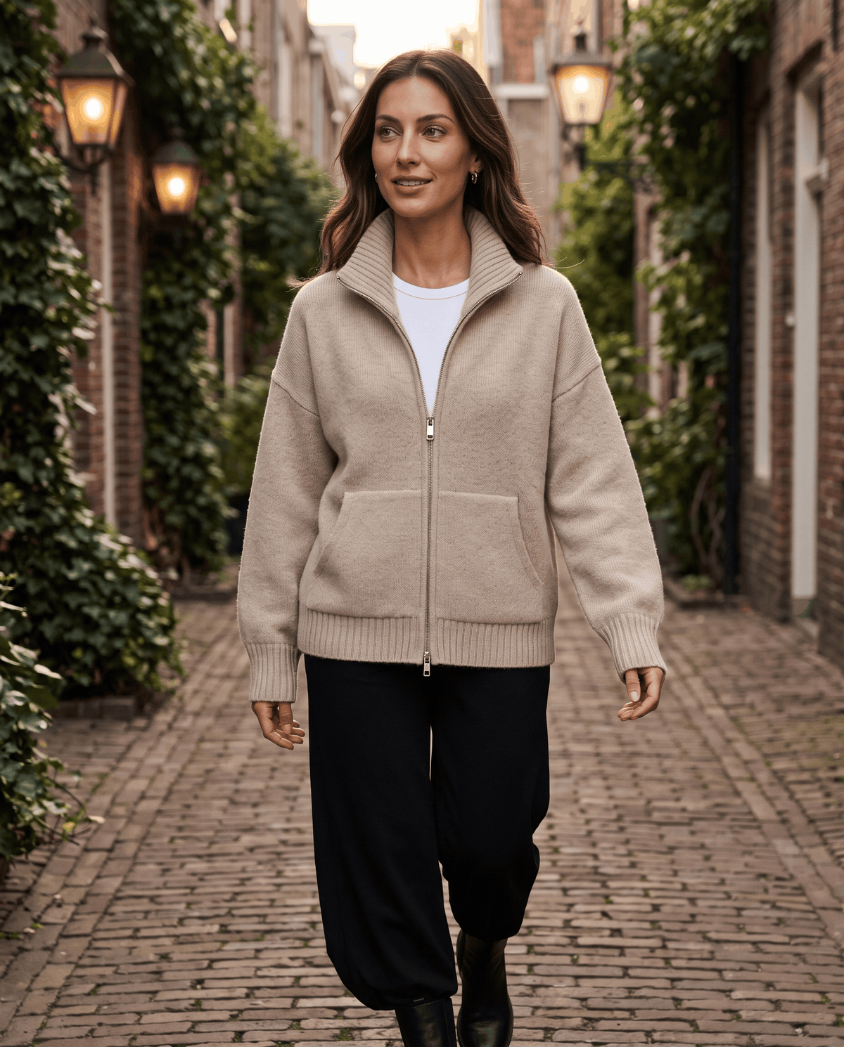 Beige zip up cardigan styled with jeans on a city street