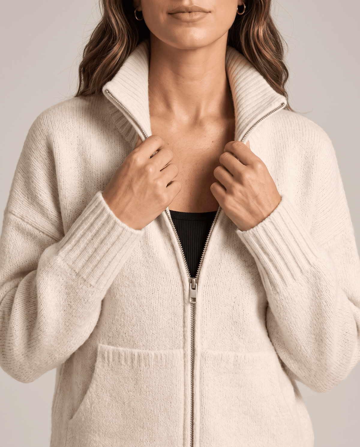 Close-up of cream soft knit with funnel collar and ribbed cuff