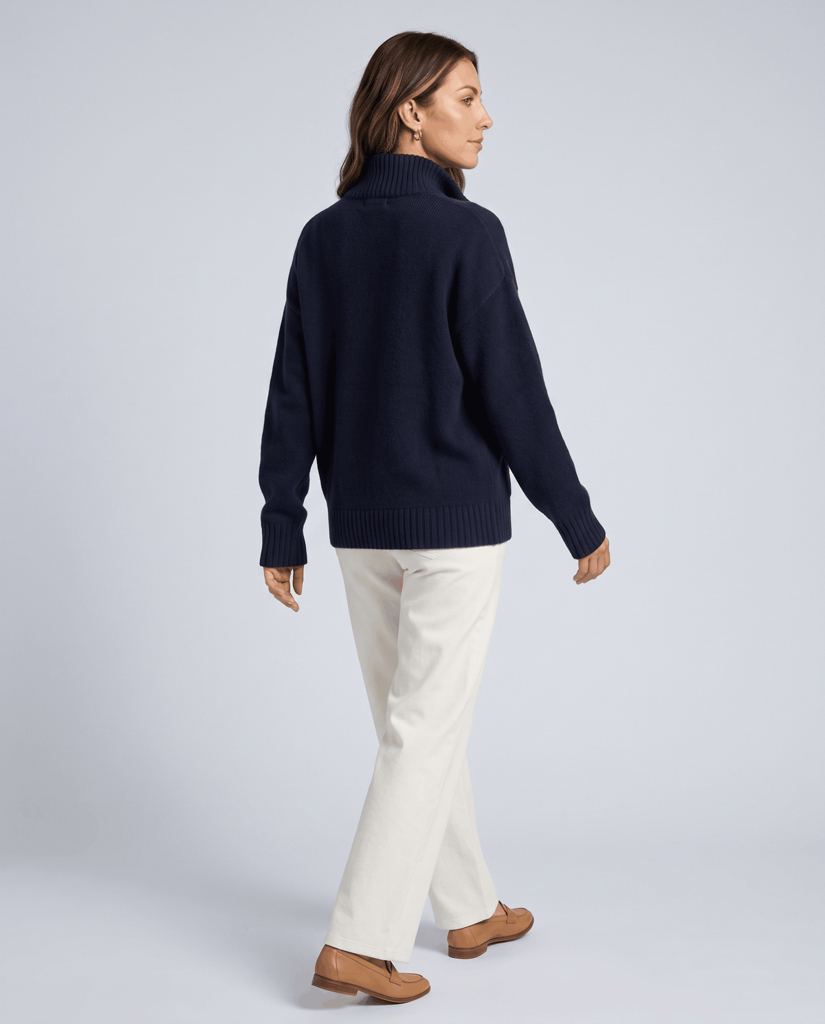 Back view of a navy zip up cardigan with a relaxed fit