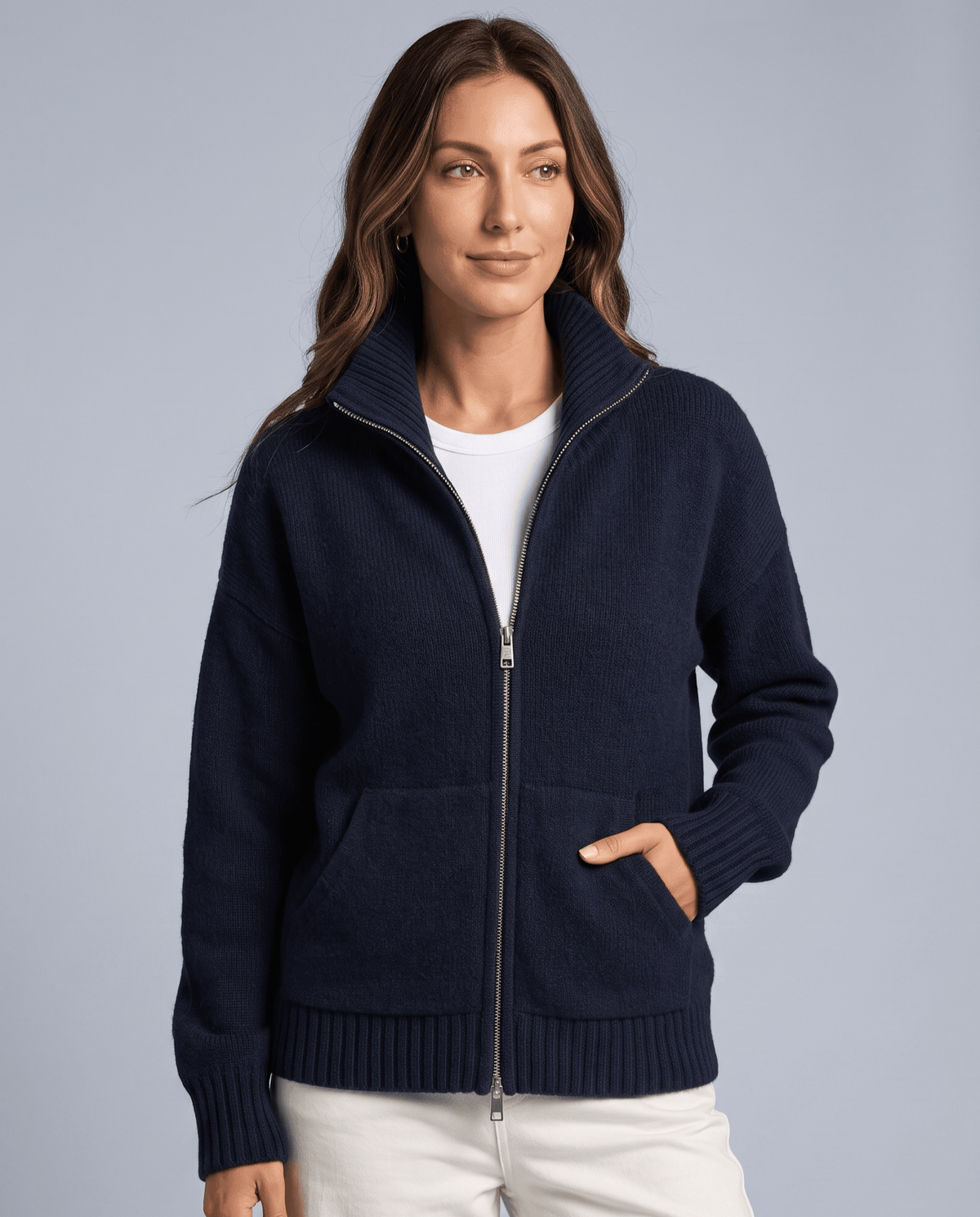 Woman wearing a navy zip cardigan with one hand in the pocket
