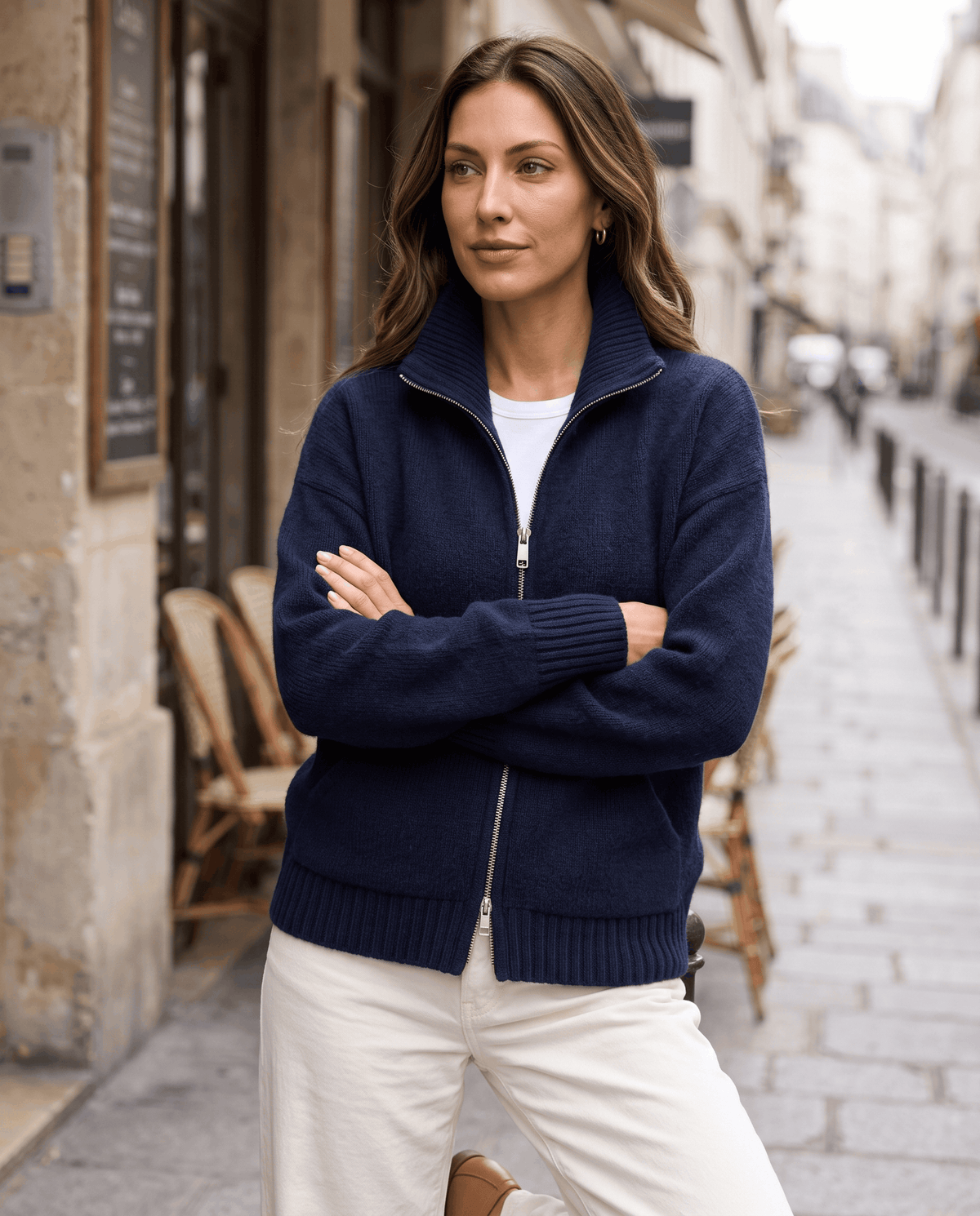 Navy zip up cardigan styled with trousers on a city street