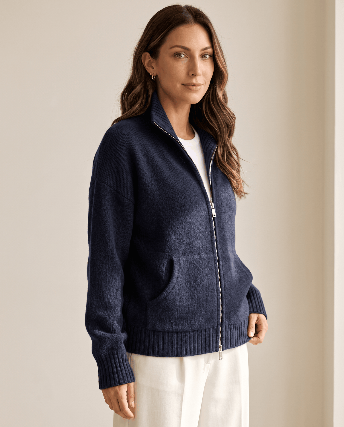 Three-quarter view of a navy cardigan with funnel neck and zip