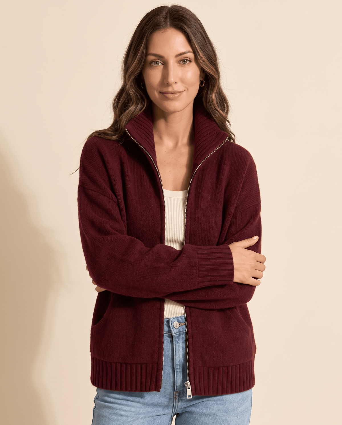 Woman wearing a wine red zip cardigan with arms crossed, front view