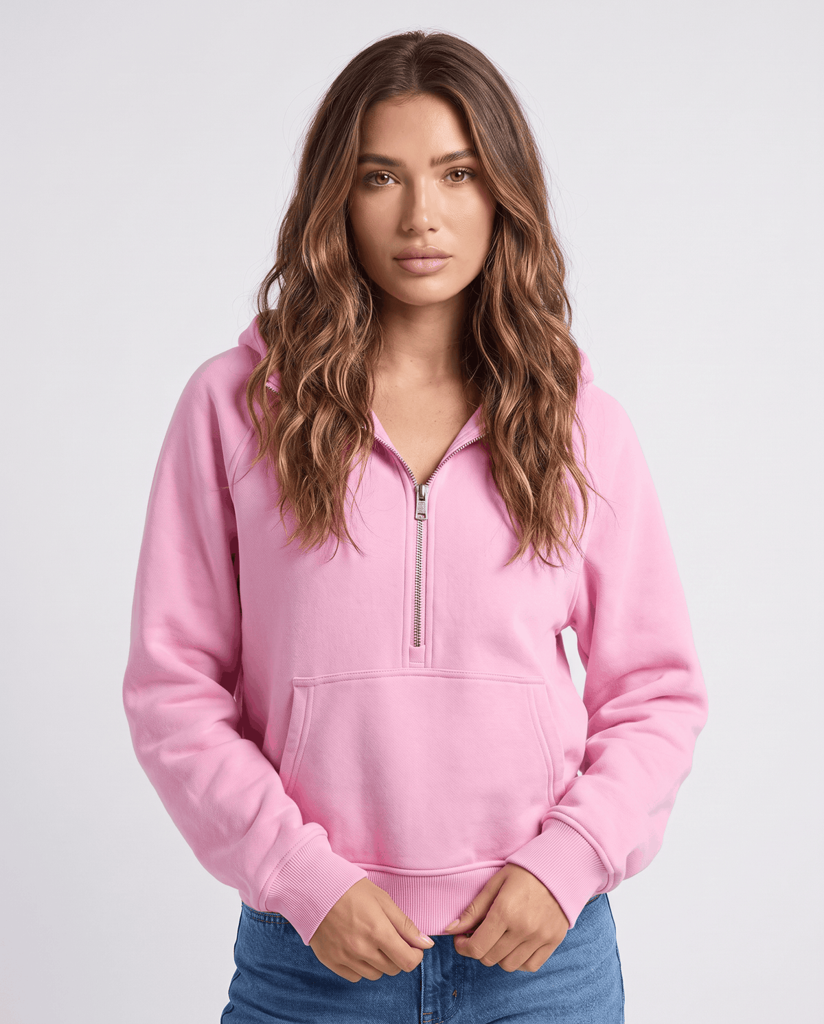 Front view of the pink relaxed fit half zip hoodie worn with jeans