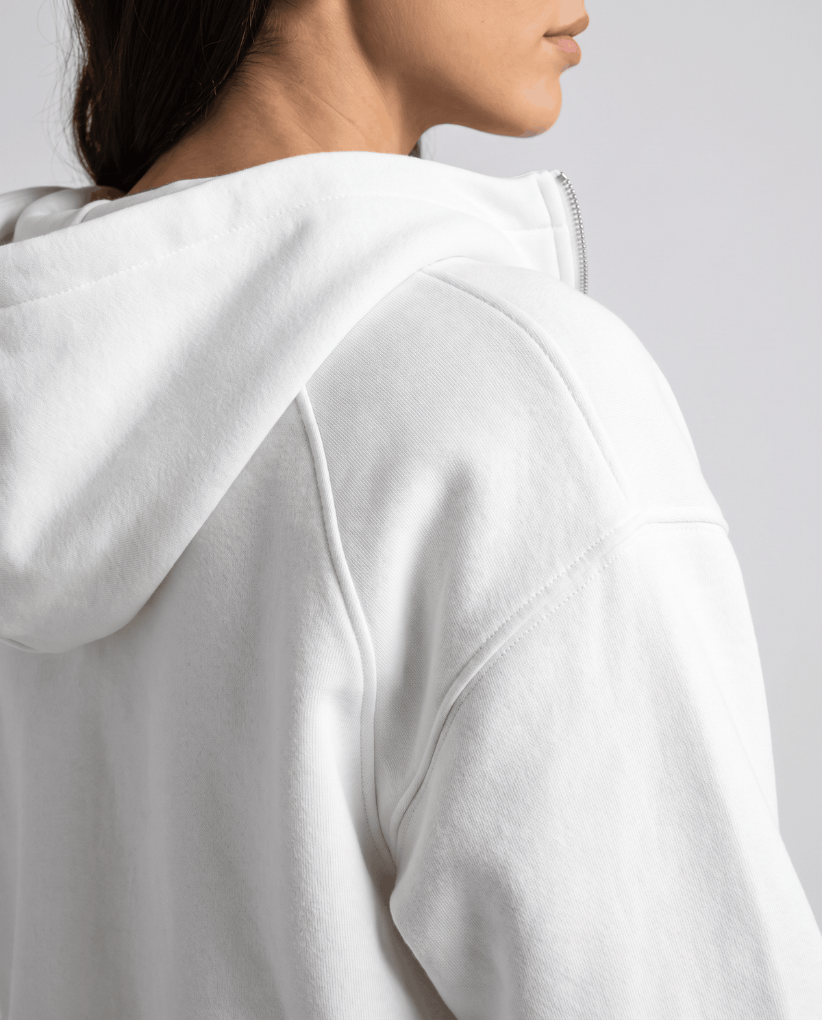 Side close-up of the white hood and drop shoulder detail on the fleece fabric