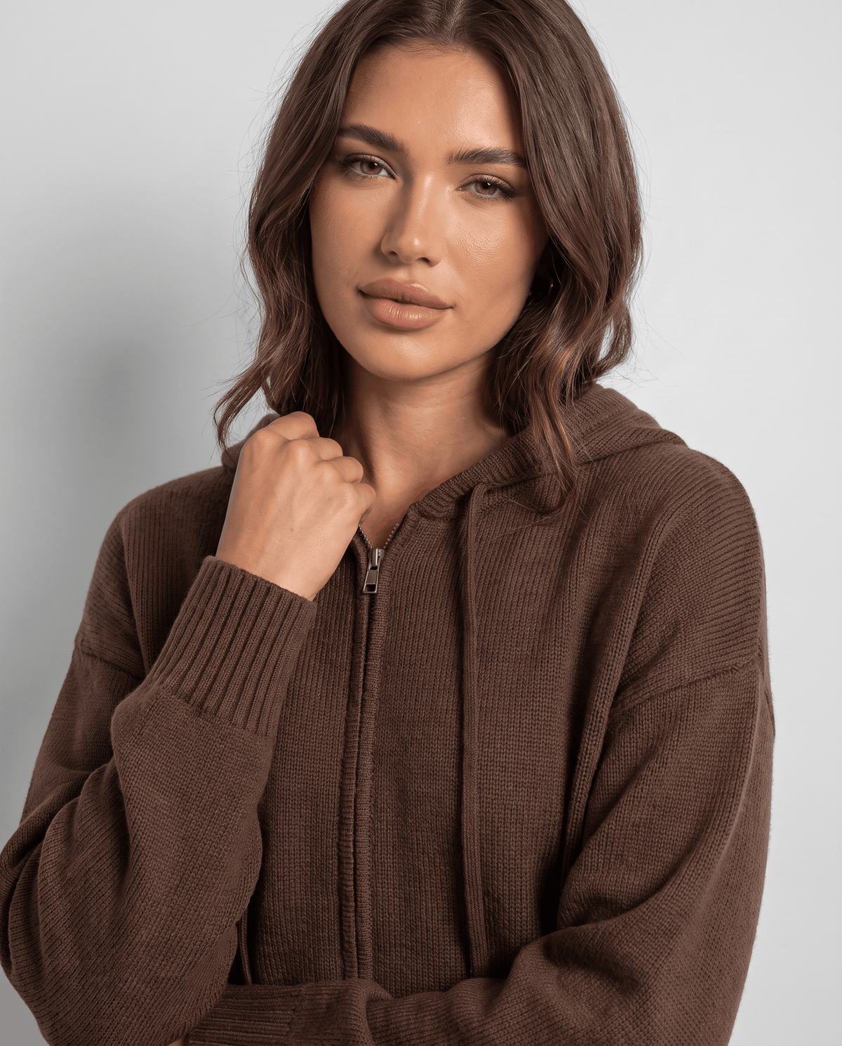 Close-up of dark brown cardigan zip front with hood drawstrings and soft knit