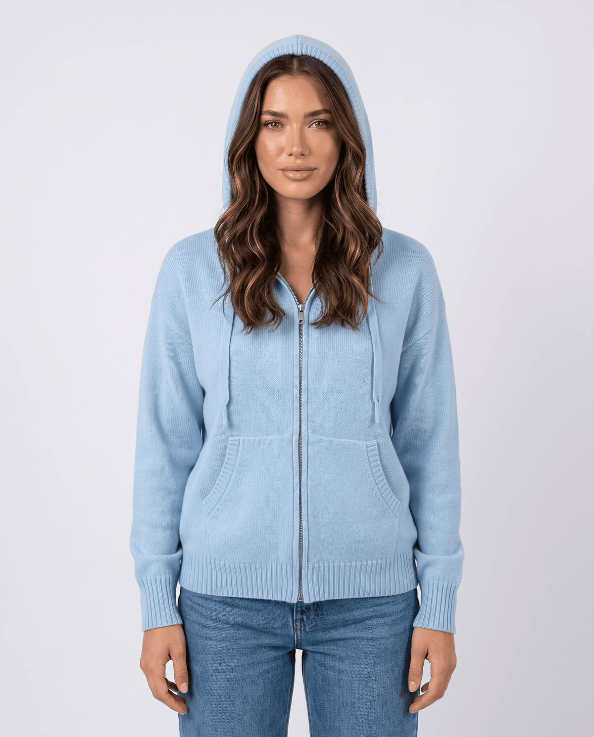 Front view of sky blue zip-up cardigan with the hood up and hands in pockets