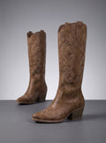 Brown pair on a dark floor showing light scroll embroidery and pointed toe