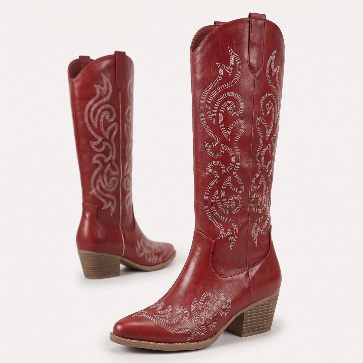 Red pair angled to show the scroll embroidery and pointed toe