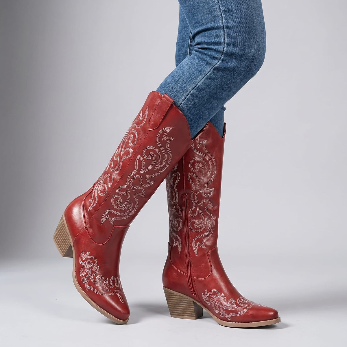 Woman in blue skinny jeans walking in red embroidered boots