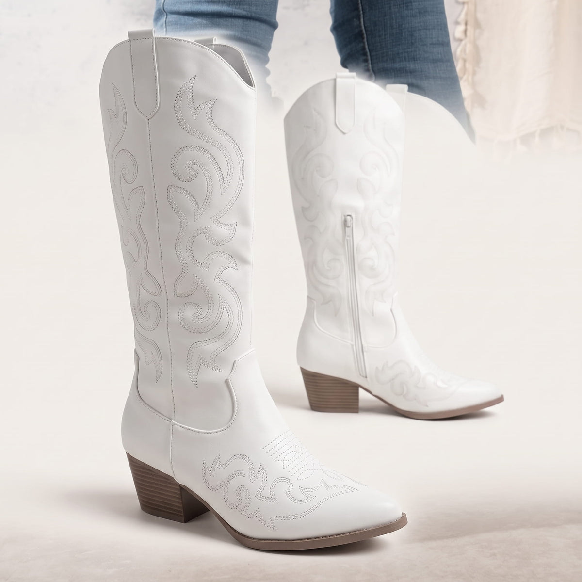 Close angle of the white pair showing the embroidered shaft and pull tabs