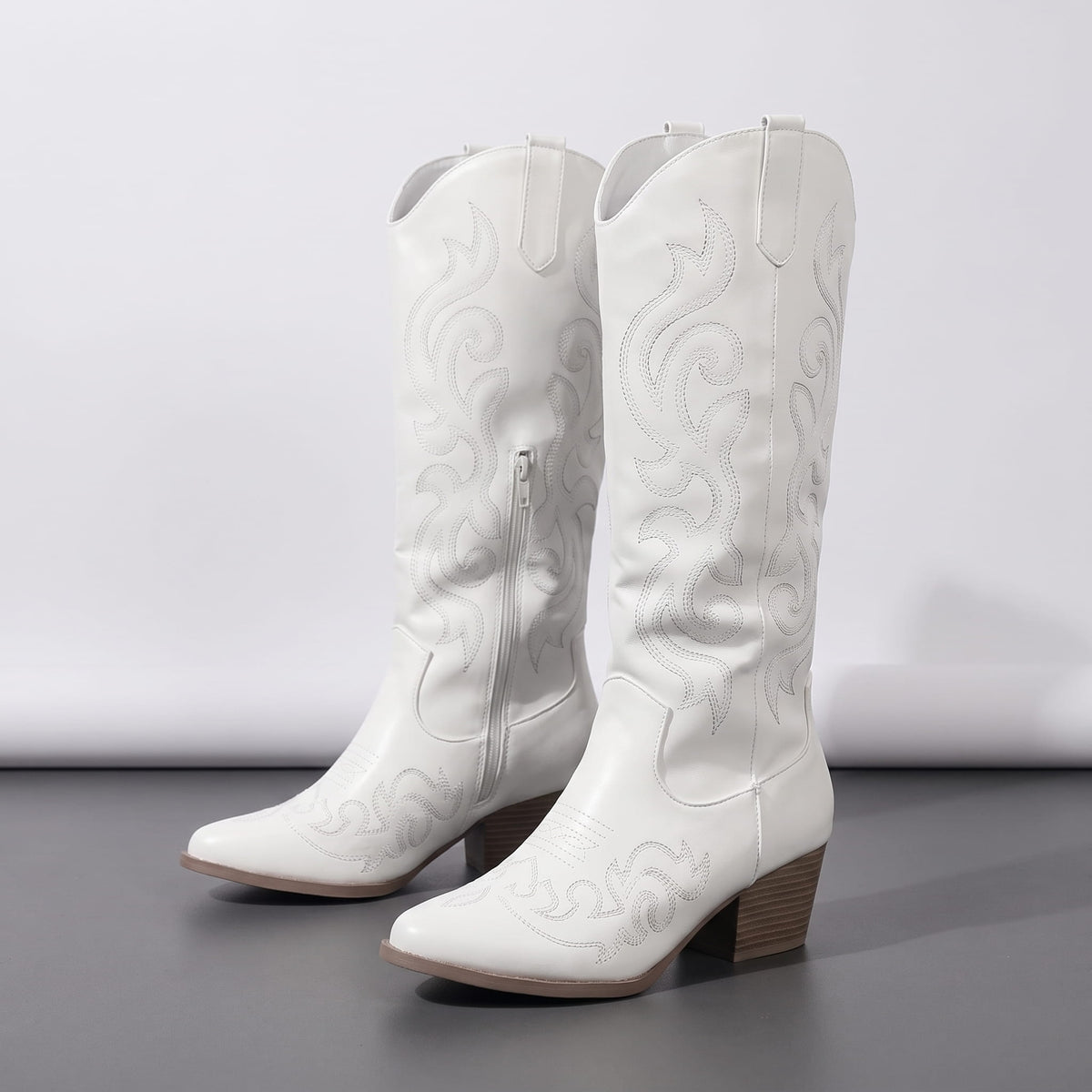 White pair on a dark floor showing tonal embroidery and stacked heel