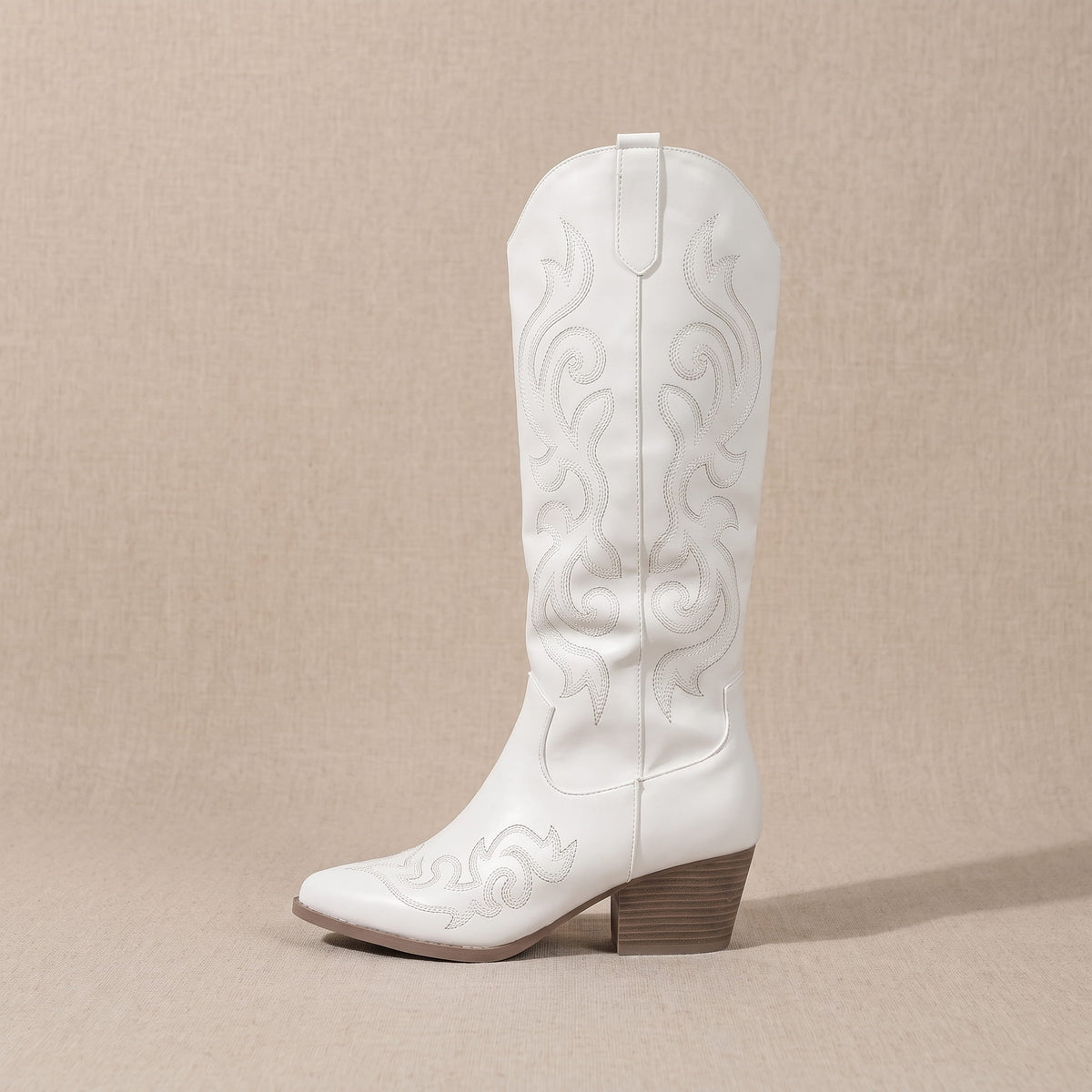 Single white boot in side profile on a beige backdrop