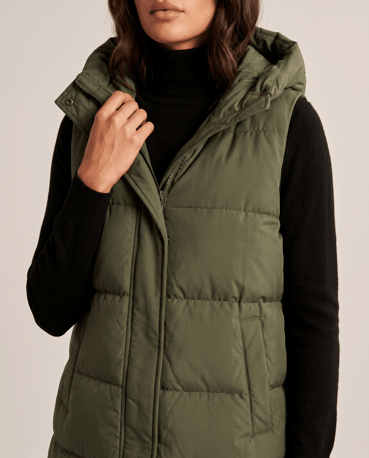 Army green long quilted vest front placket and hood shown in close view