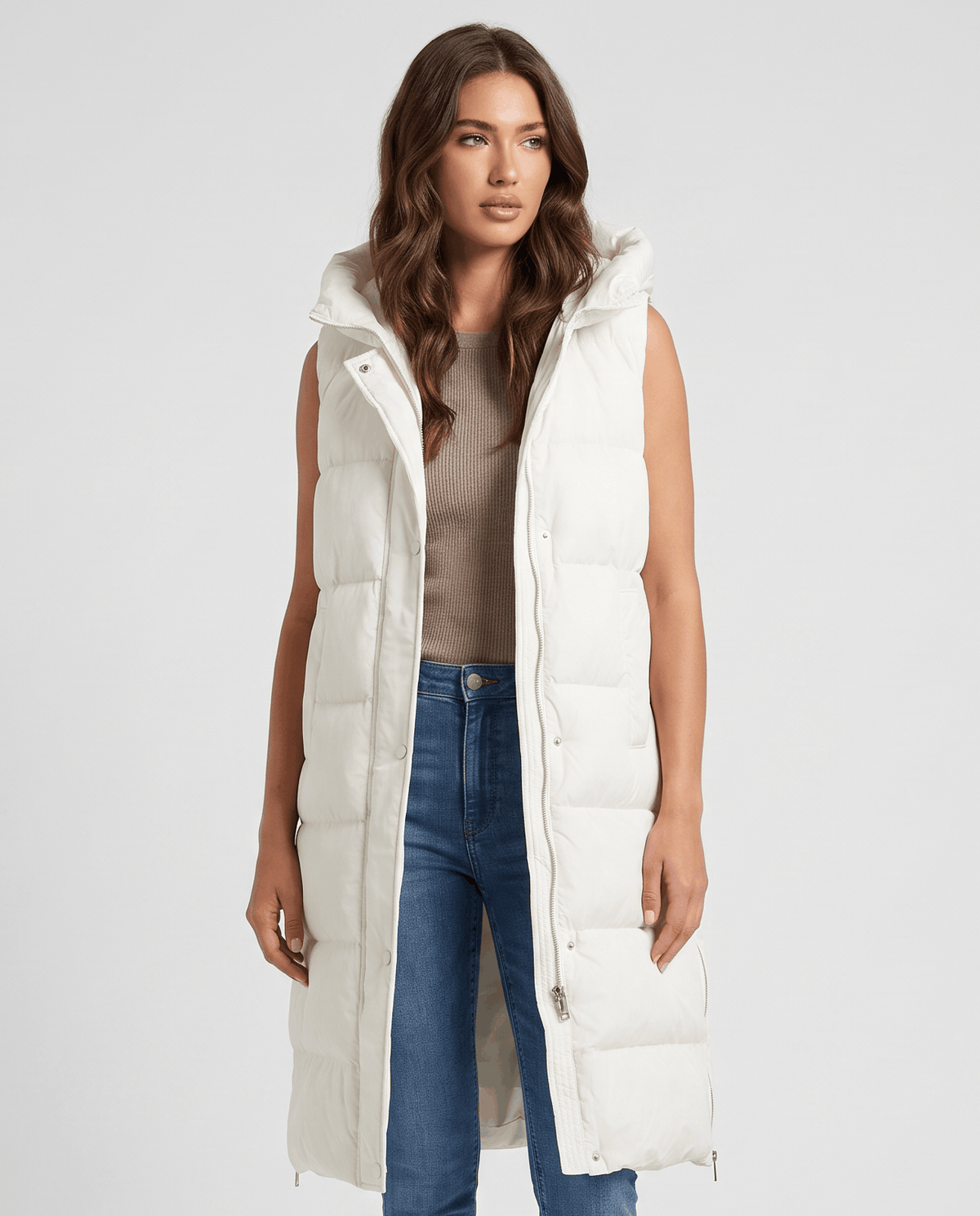 Cream long quilted hooded vest worn over a brown top and blue jeans
