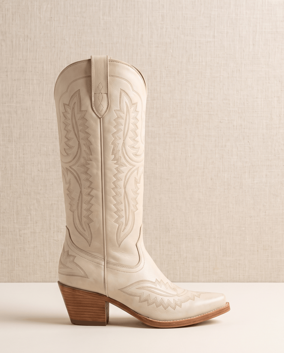 Single cream western boot in side profile showing tonal embroidery and stacked heel