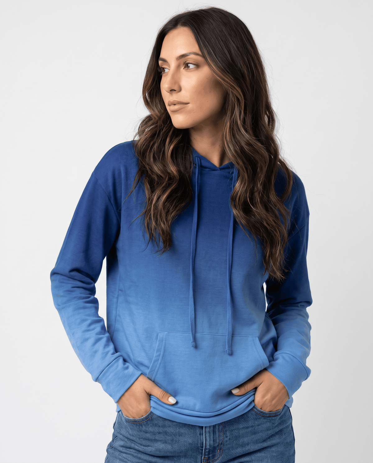 Women's ombre hoodie in blue with drawstring hood and kangaroo pocket, hands in jeans pockets