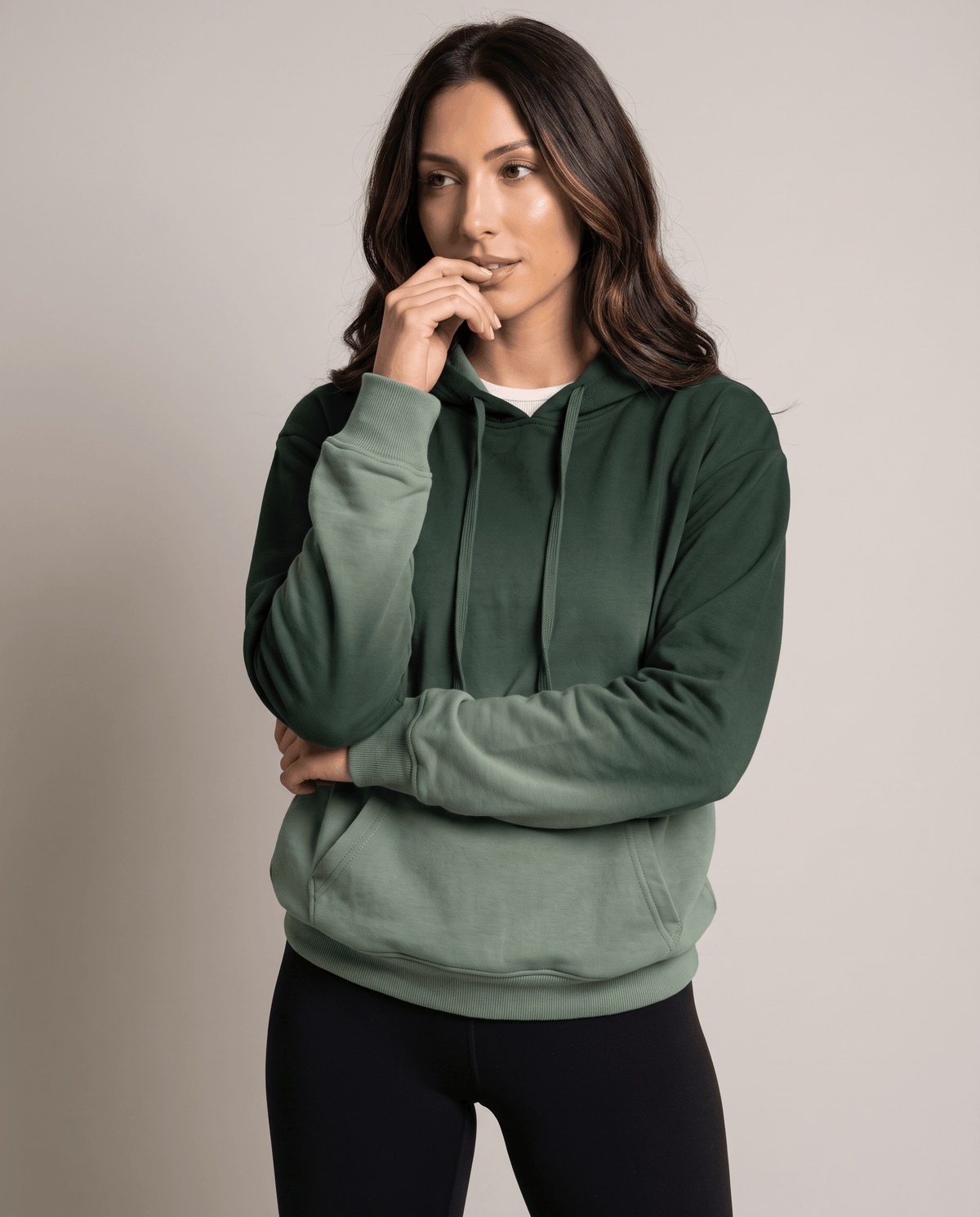 Green fade pullover with drawstring hood layered over a white top, front view with black leggings