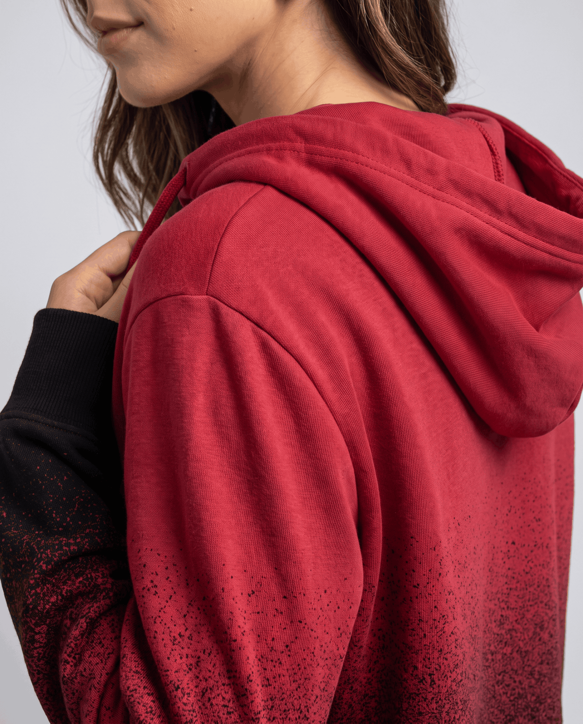 Side close-up of the red hood and sleeve fading to black at the cuff