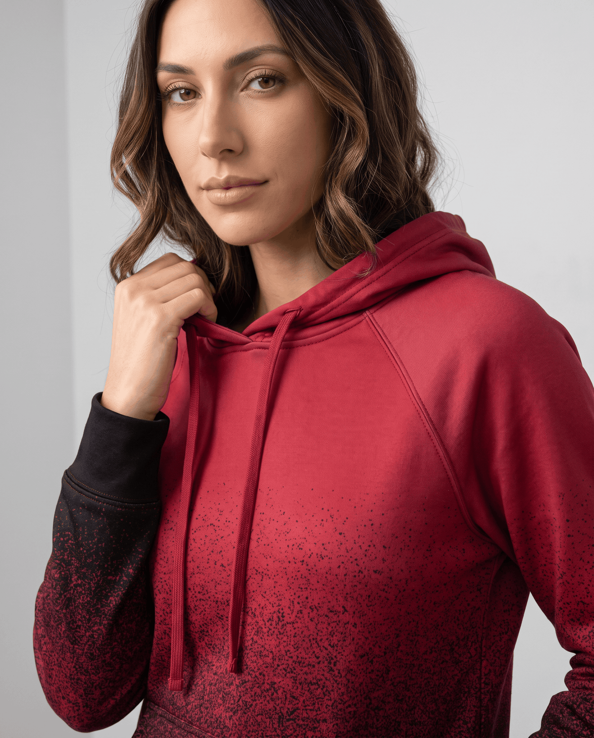 Close-up of the red pullover with black speckled fade on the sleeve and drawstrings