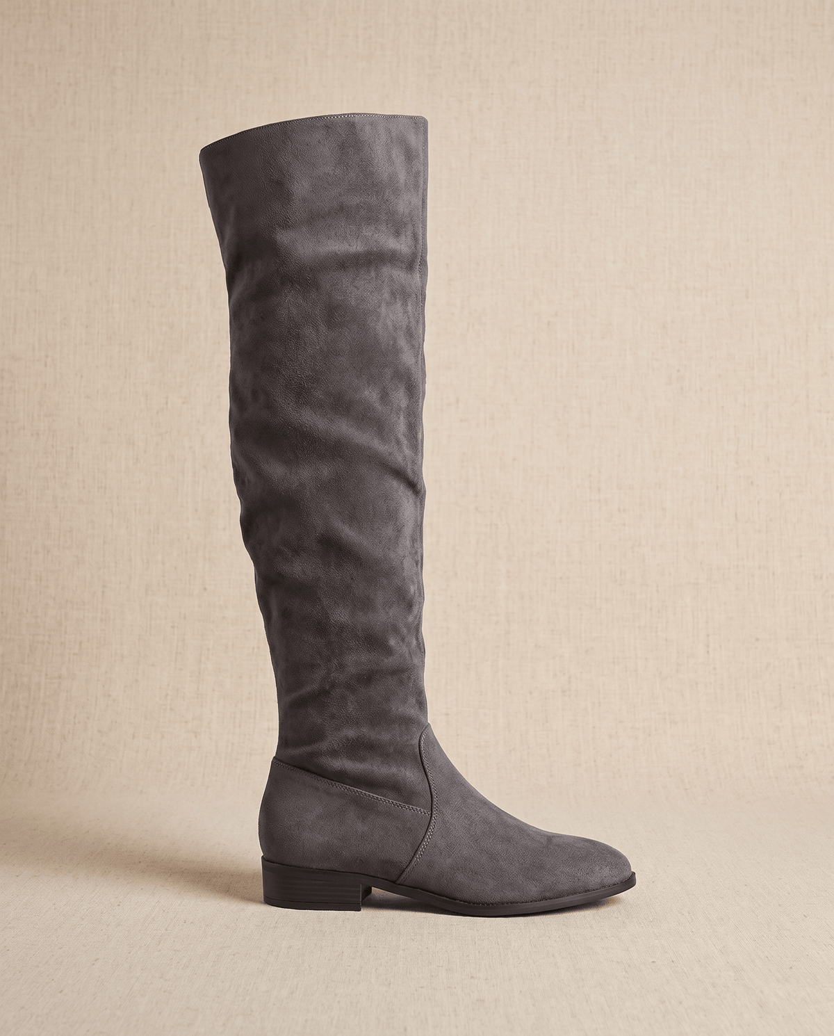 Single gray boot in side profile on a beige backdrop