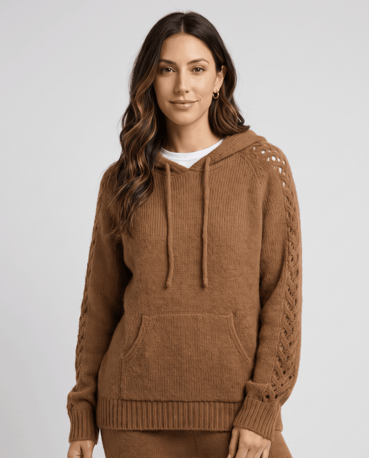 Brown hooded sweater with drawstring and front pocket worn over a white top, front view