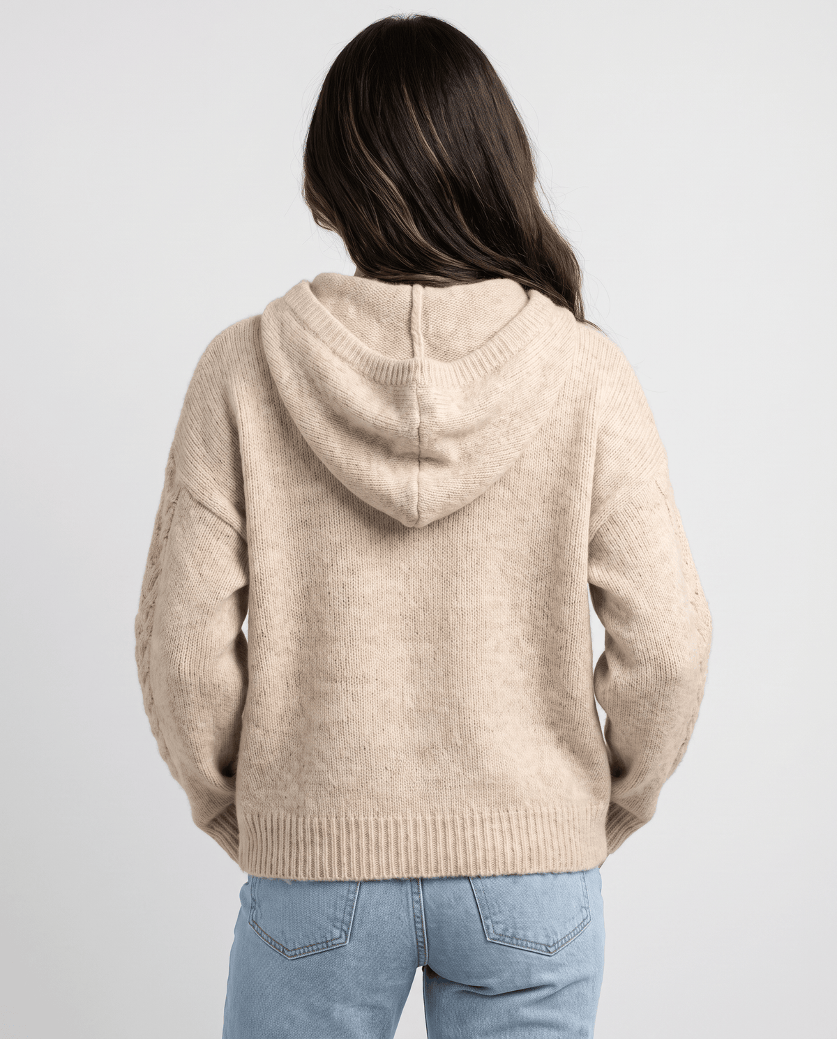 Back view of the light brown knit sweater with the hood resting over the shoulders