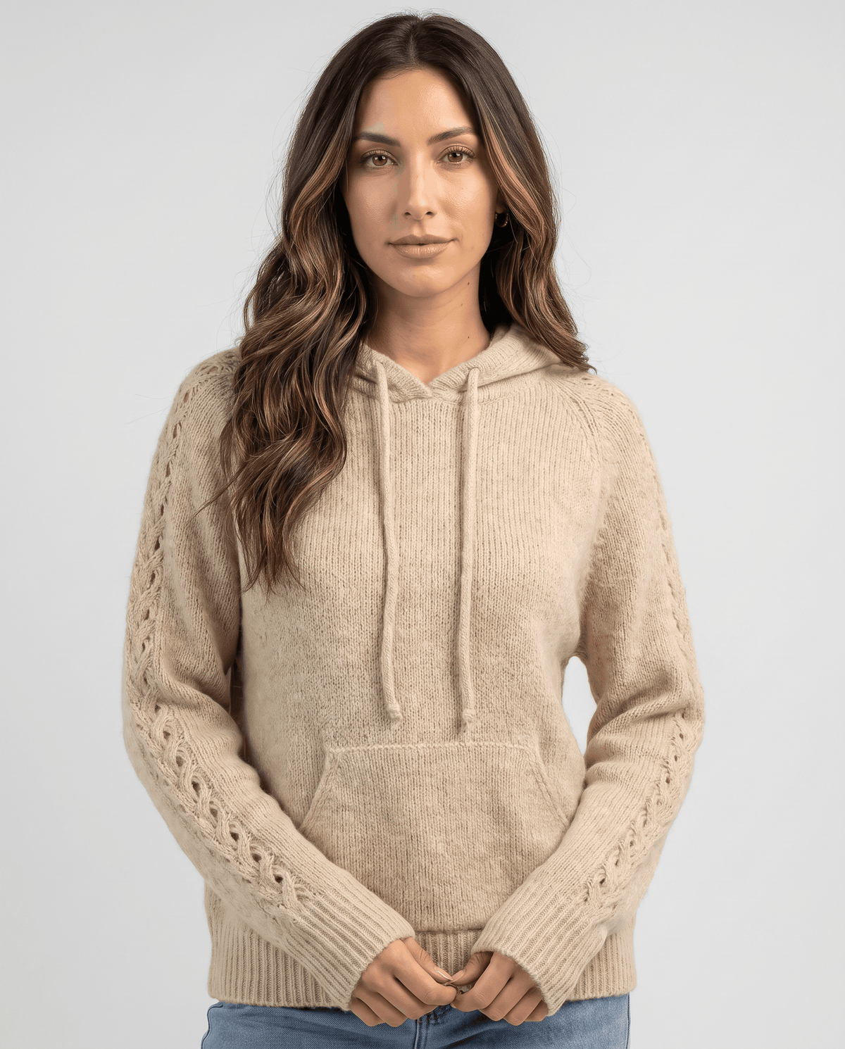 Light brown hooded sweater with drawstring and front pocket worn with jeans, front view