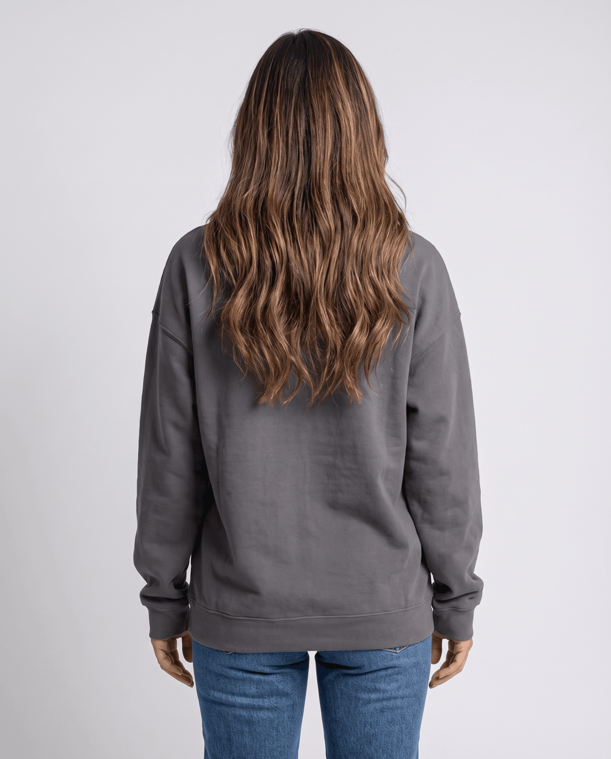 Back view of the gray loose-fit hoodie over jeans